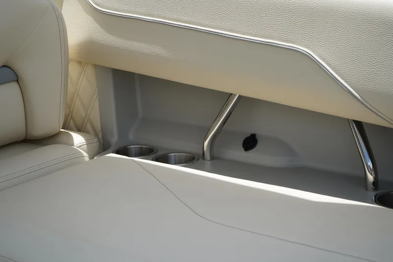 Slide: The Image of 2023 Regal LX4 boat interior with beige seating and cup holders. - 15