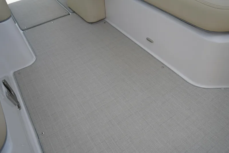 Slide: The Image of 2023 Regal LX4 boat interior with beige seating and textured flooring. - 16