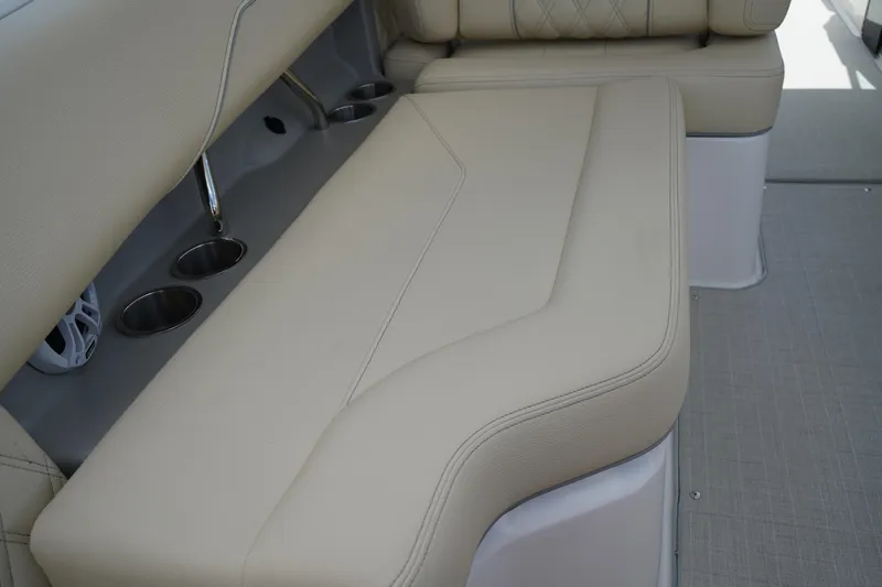Slide: The Image of 2023 Regal LX4 boat interior with beige seating and cup holders. - 19