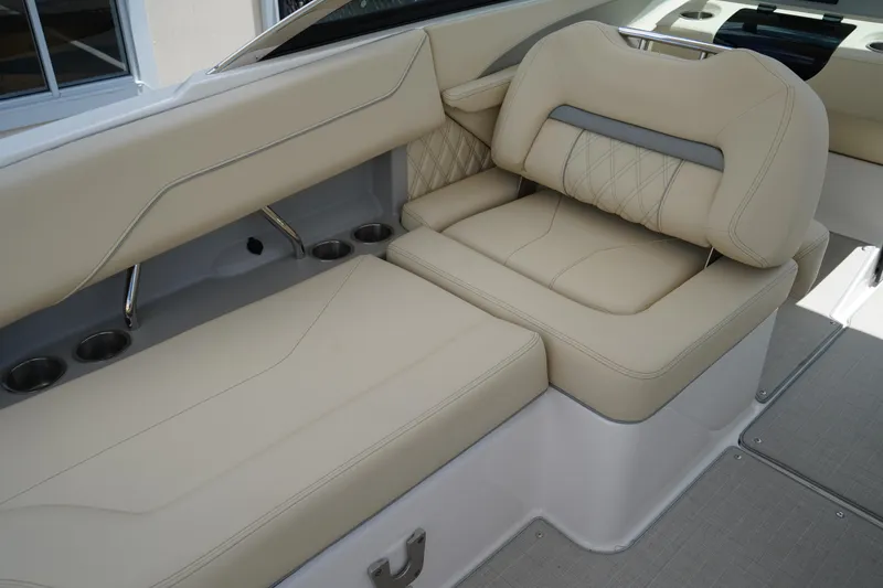 Slide: The Image of 2023 Regal LX4 boat interior with beige leather seating and cup holders. - 26