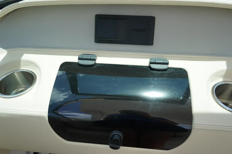 Slide: The Image of Dashboard of 2023 Regal LX4 boat with cup holders and storage compartment. - 27