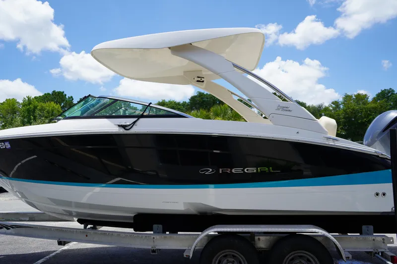 Slide: The Image of 2023 Regal LX4 boat on trailer under blue sky. - 3