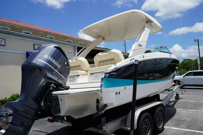 Slide: The Image of 2023 Regal LX4 boat on trailer with Yamaha outboard motor, parked outdoors. - 4