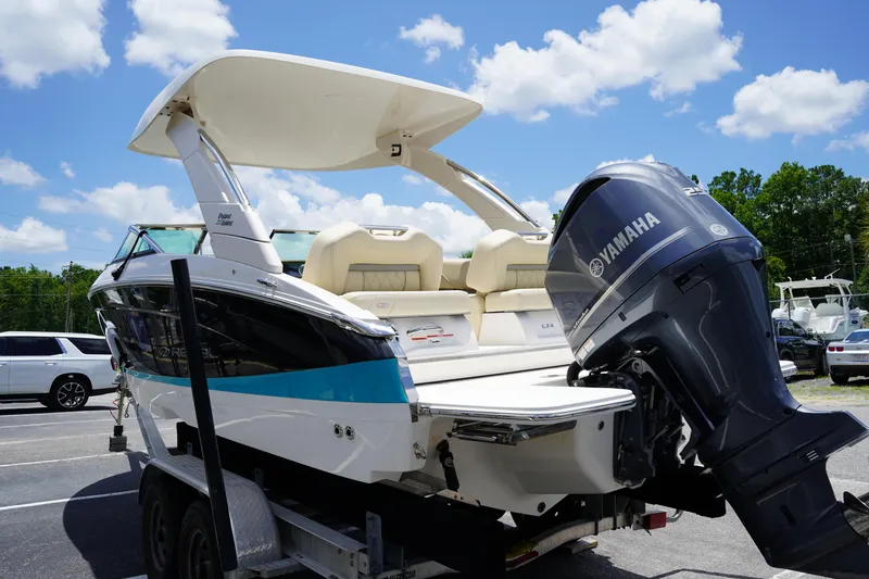 Slide: The Image of 2023 Regal LX4 boat with Yamaha outboard motor on a trailer, under a sunny sky. - 5