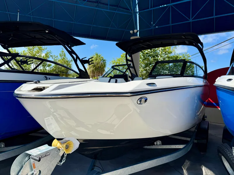 Slide: The Image of 2025 Yamaha Boats 252SD in showroom, sleek design under blue canopy. - 5