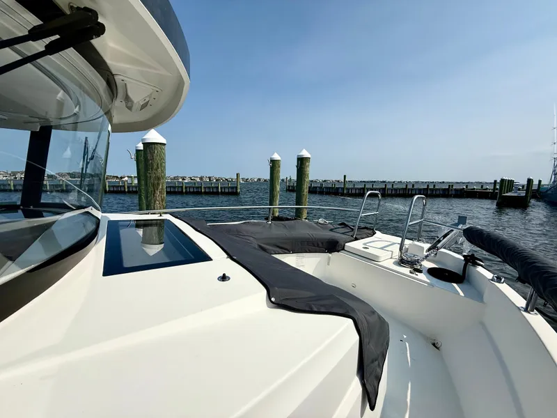 Slide: The Image of 2020 Jeanneau NC Sport 895 boat docked at a marina with clear skies. - 16