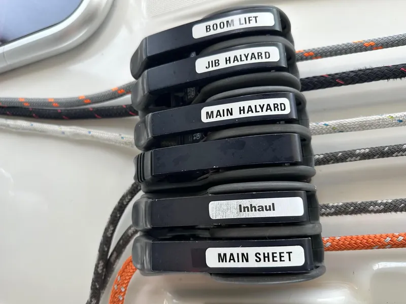 Slide: The Image of Beneteau Oceanis 50 sailboat control lines labeled: boom lift, jib halyard, main halyard, inhaul, main sheet. - 11