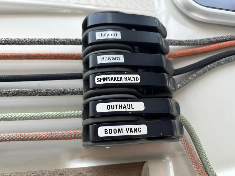 Slide: The Image of Sailing controls on a 2014 Beneteau Oceanis 50, labeled halyards, spinnaker, outhaul, boom vang. - 12