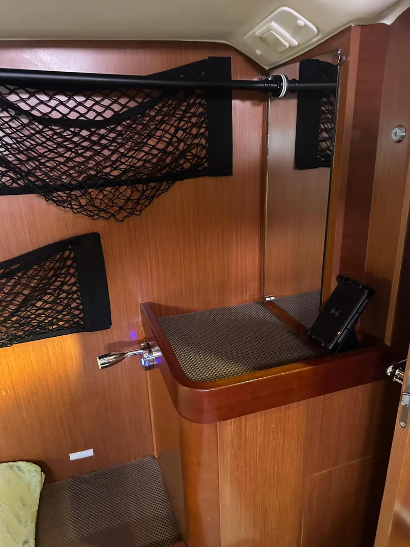 Slide: The Image of Interior of 2014 Beneteau Oceanis 50 sailboat with wooden finish and storage nets. - 24