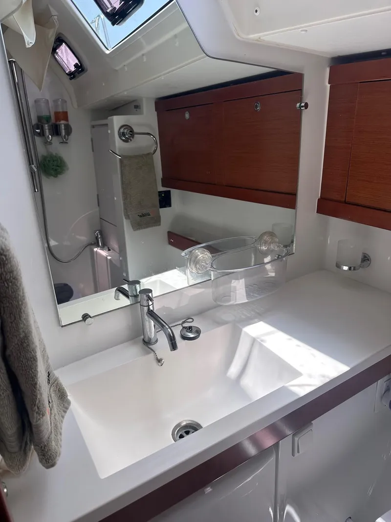 Slide: The Image of Beneteau Oceanis 50 bathroom interior, featuring a sleek sink and wooden cabinetry, 2014 model. - 27