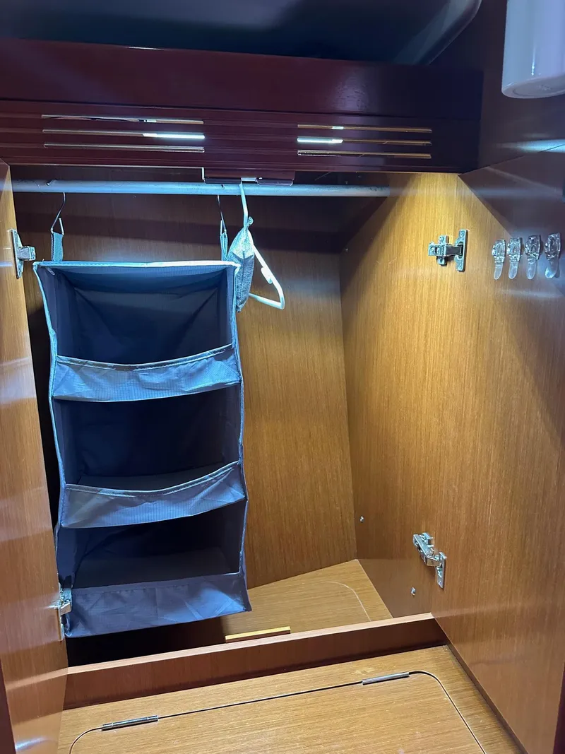 Slide: The Image of 2014 Beneteau Oceanis 50 yacht closet with hanging organizer and wooden finish. - 28