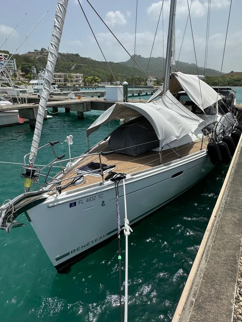 Slide: The Image of 2014 Beneteau Oceanis 50 sailboat docked in a marina with turquoise water. - 4