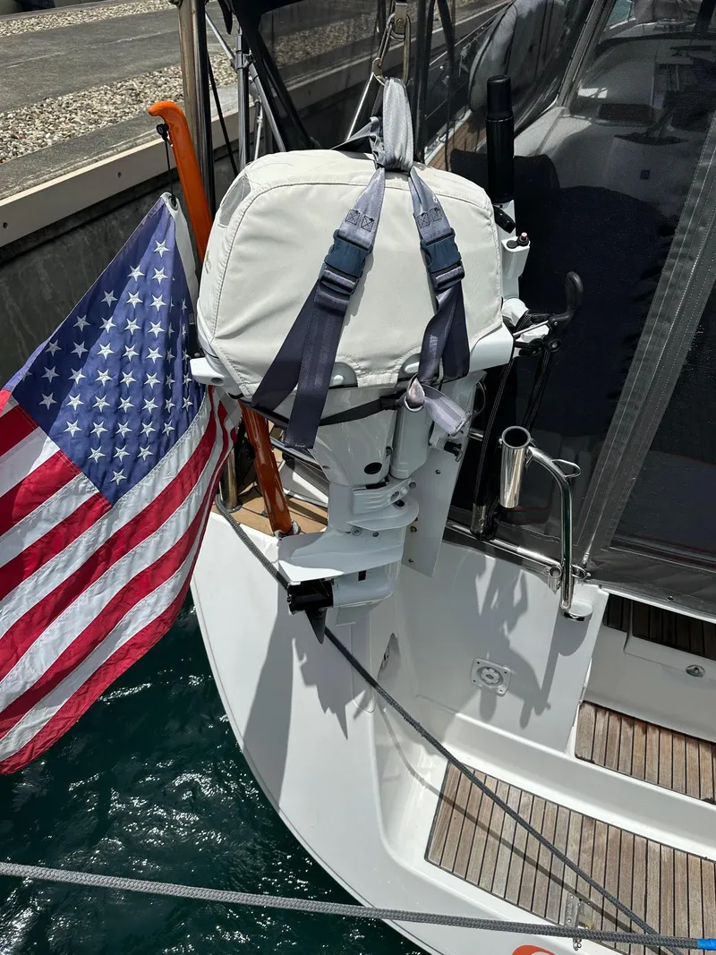 Slide: The Image of 2014 Beneteau Oceanis 50 sailboat with American flag and covered outboard motor. - 43