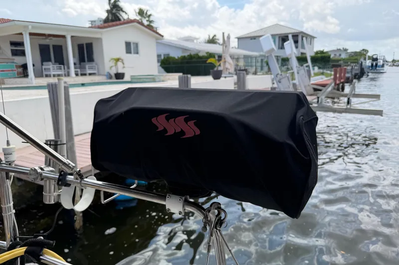 Slide: The Image of Beneteau Oceanis 50 (2014) docked, featuring covered equipment, waterfront homes in background. - 65