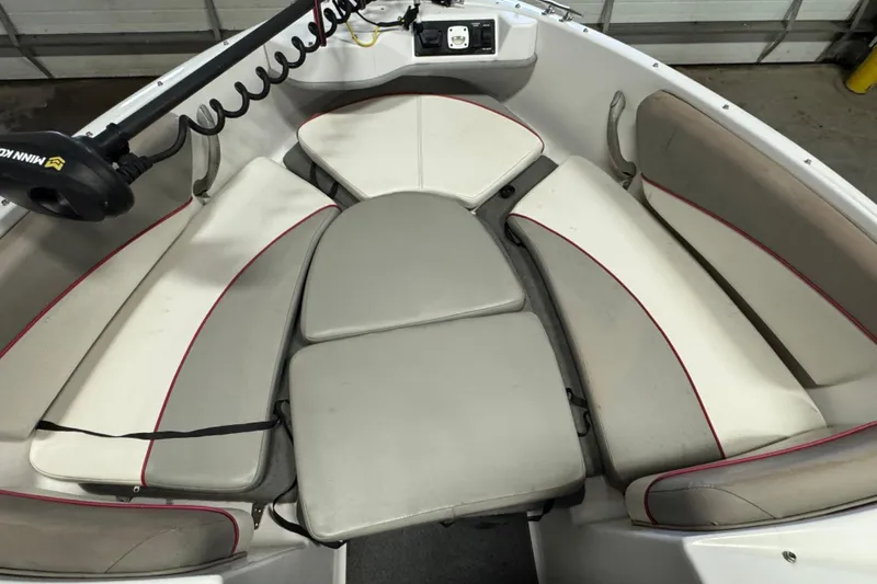 Slide: The Image of 2000 Four Winns 180 Horizon boat interior with cushioned seating and Minn Kota trolling motor. - 14