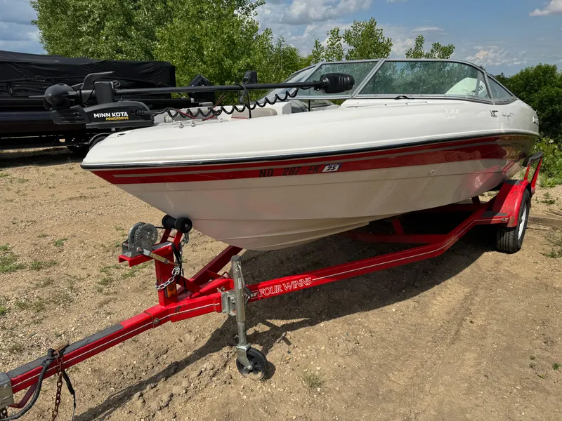 Slide: The Image of 2000 Four Winns 180 Horizon boat on red trailer in indoor storage. - 2