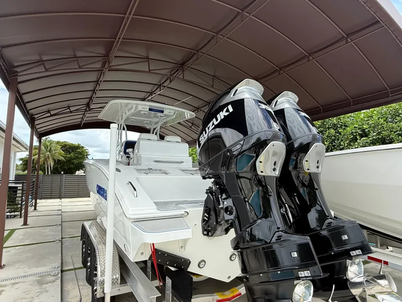 Slide: The Image of 2024 Carrera Powerboats 320CC Classic with dual Suzuki engines under a canopy. - 1