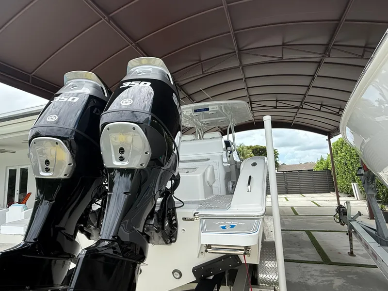 Slide: The Image of 2024 Carrera Powerboats 320CC Classic with dual 350 engines under a canopy. - 2