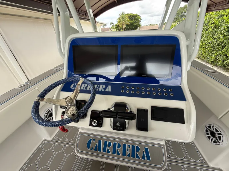 Slide: The Image of 2024 Carrera Powerboats 320CC Classic dashboard with dual screens and steering wheel. - 20
