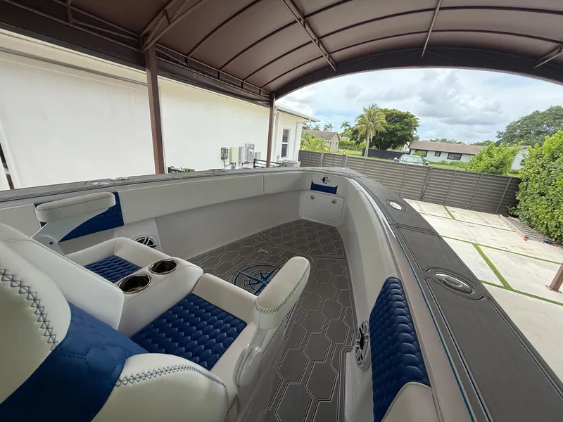 Slide: The Image of 2024 Carrera Powerboats 320CC Classic interior with blue and white seating under a canopy. - 30
