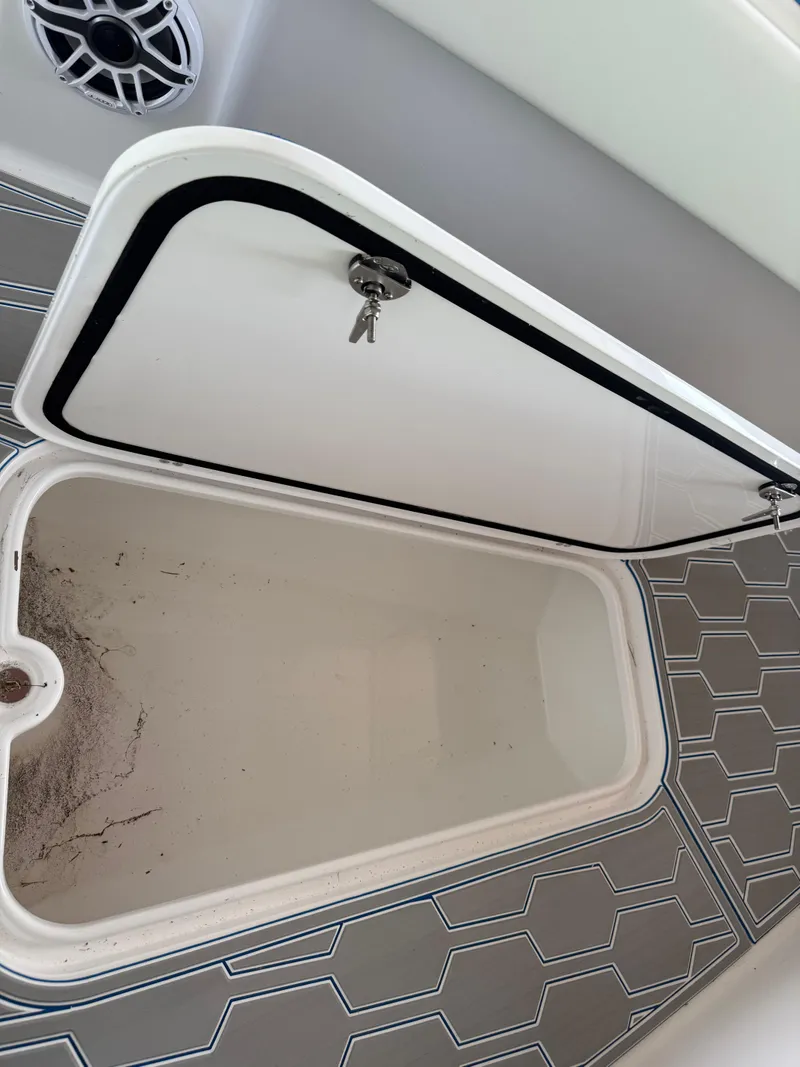Slide: The Image of 2024 Carrera Powerboats 320CC Classic storage compartment with open hatch and key. - 34