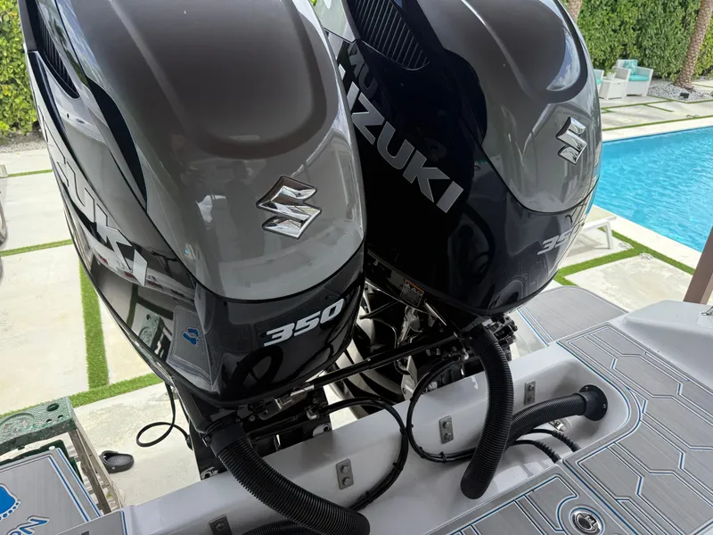 Slide: The Image of Twin Suzuki 350 outboard engines on a 2024 Carrera Powerboats 320CC Classic by a poolside. - 36