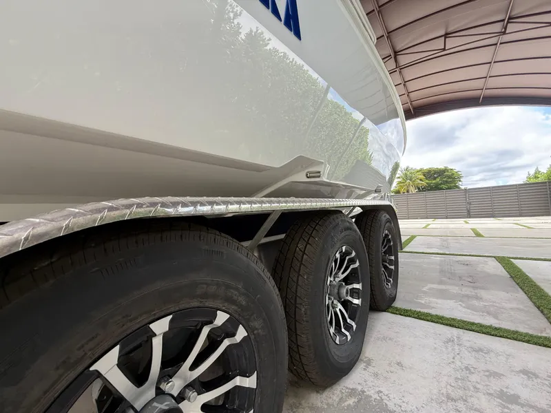 Slide: The Image of 2024 Carrera Powerboats 320CC Classic on trailer, showcasing sleek design and triple-axle wheels. - 45