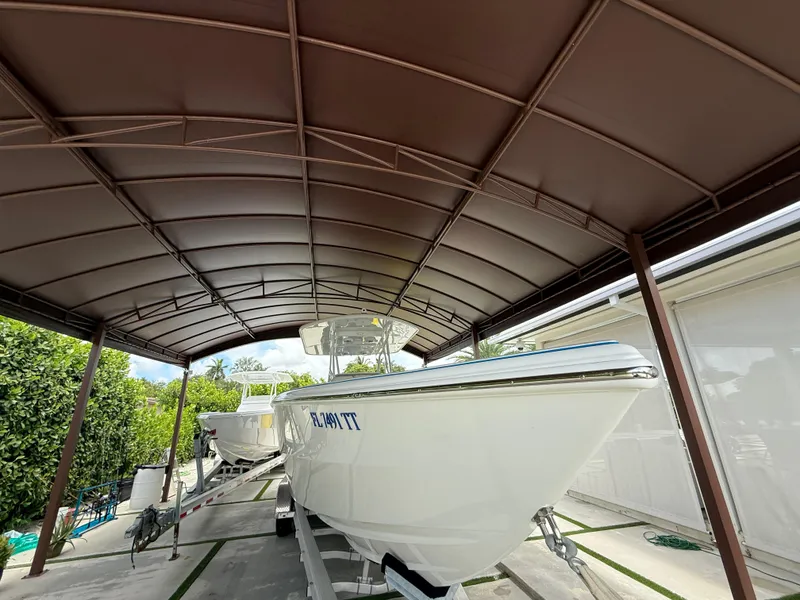 Slide: The Image of 2024 Carrera Powerboats 320CC Classic under a metal canopy, parked on a trailer. - 49