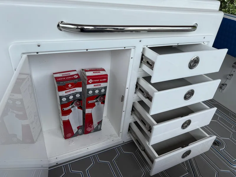 Slide: The Image of Storage compartment with fire extinguishers on a 2024 Carrera Powerboats 320CC Classic. - 7