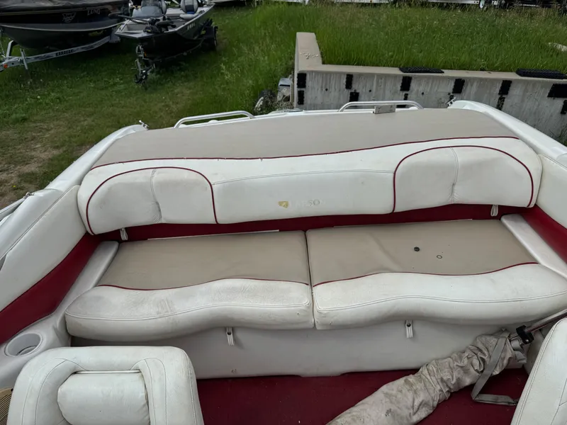 Slide: The Image of 1998 Larson 195 boat interior with beige and red cushioned seating. - 10