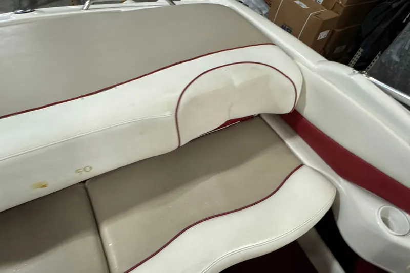 Slide: The Image of 1998 Larson 195 boat interior with beige and red seating, showing slight wear. - 12