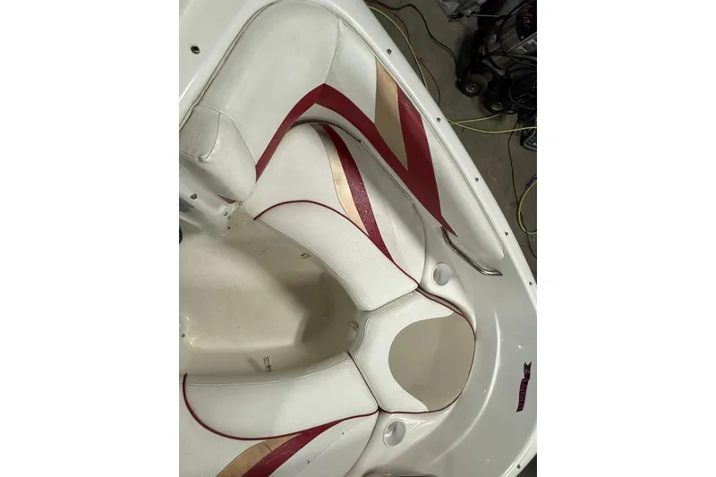 Slide: The Image of White and red interior of a 1998 Larson 195 boat, featuring cushioned seating. - 16