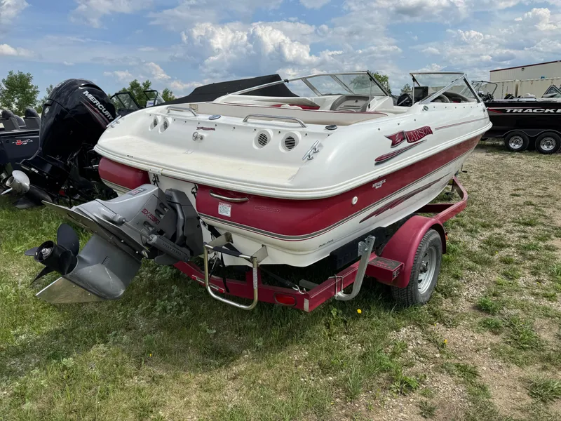 Slide: The Image of 1998 Larson 195 boat on red trailer in garage setting. - 2