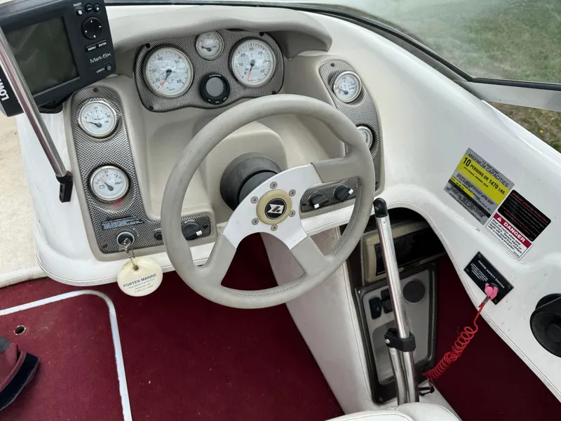 Slide: The Image of 1998 Larson 195 boat on trailer in a garage setting. - 4