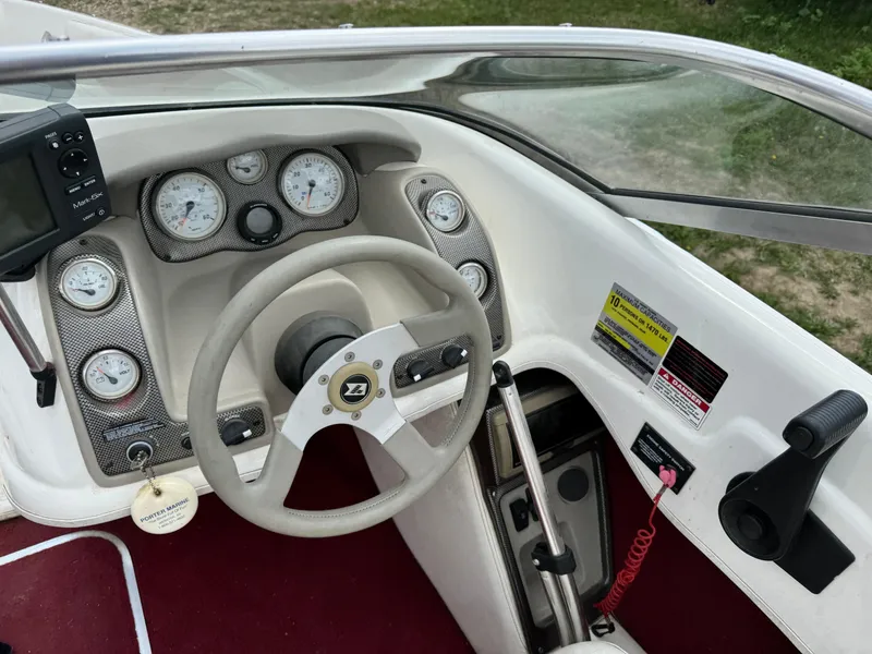 Slide: The Image of 1998 Larson 195 boat in a garage, red and white design, on a trailer. - 5