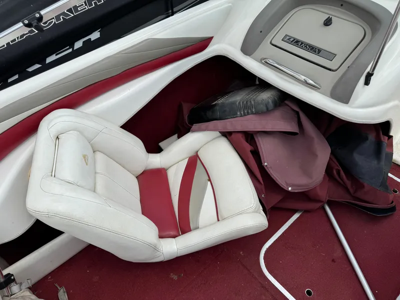 Slide: The Image of 1998 Larson 195 boat cockpit with steering wheel and gauges, featuring red and white seating. - 6