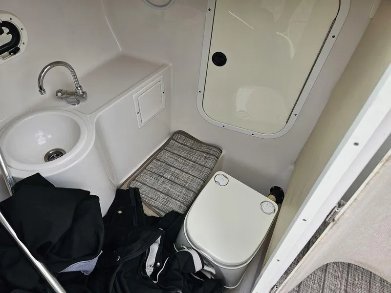 Slide: The Image of 2006 Four Winns 290 Horizon boat bathroom with sink, toilet, and storage. - 12