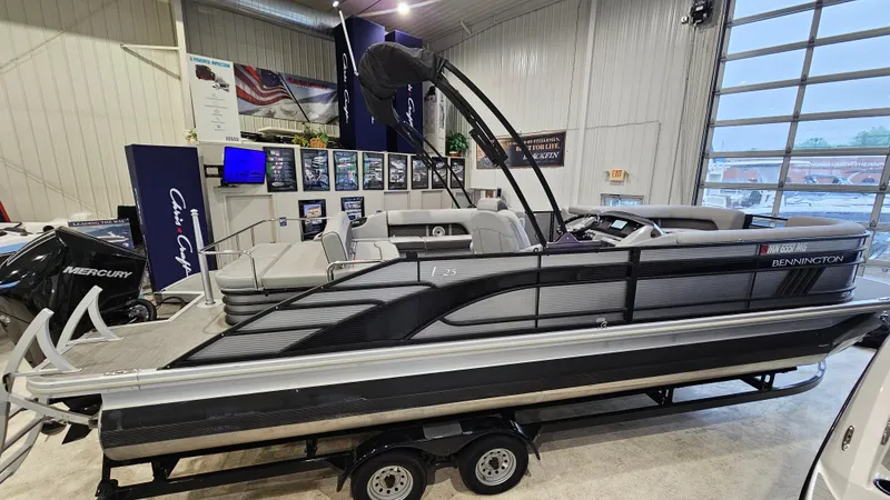 The Image of 2020 Bennington L 25 Swingback pontoon boat displayed indoors on a trailer. - 1