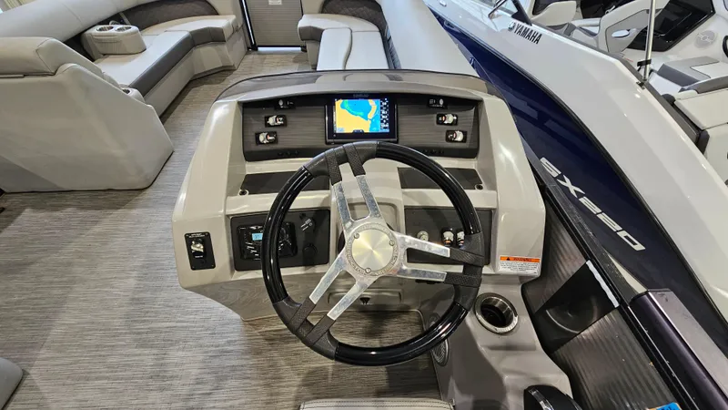 Slide: The Image of 2020 Bennington L 25 Swingback boat dashboard with steering wheel and navigation display. - 12