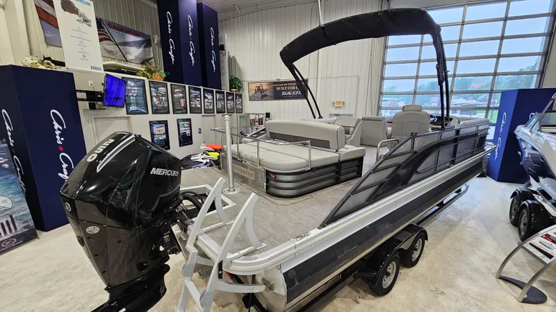 Slide: The Image of 2020 Bennington L 25 Swingback pontoon boat displayed indoors with Mercury engine. - 2