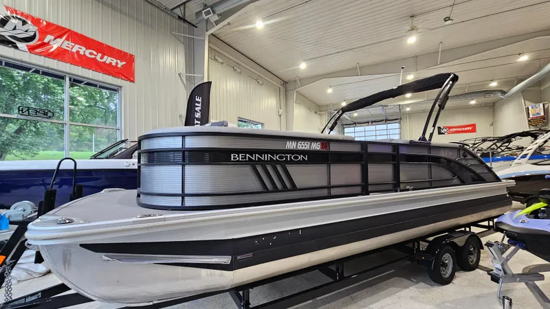 Slide: The Image of 2020 Bennington L 25 Swingback pontoon boat displayed indoors on a trailer. - 4