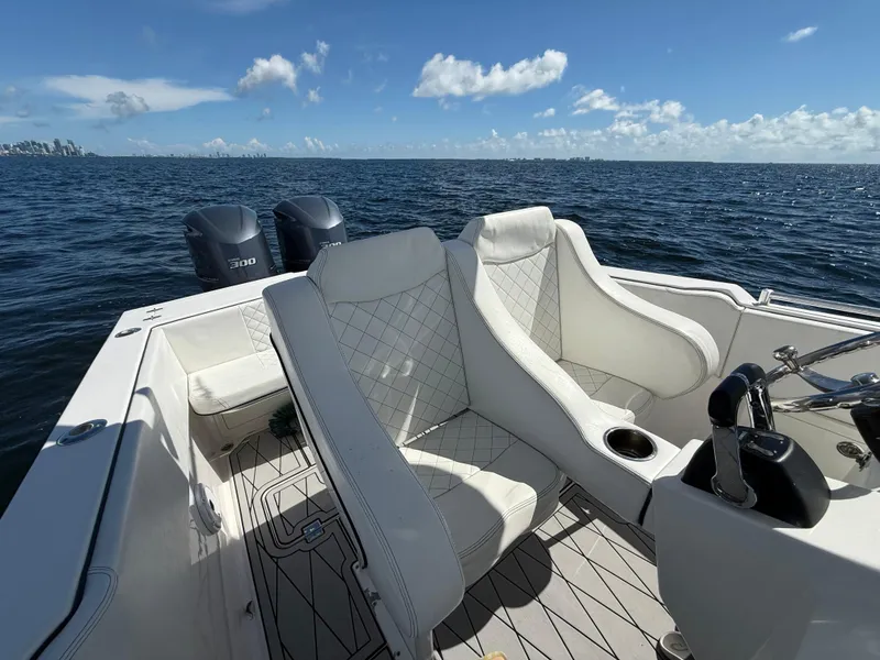 Slide: The Image of 2021 Avance 33 Cabriolet boat interior with white seating, ocean view, and dual engines. - 13