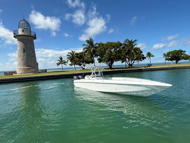 Slide: The Image of 2021 Avance 33 Cabriolet boat near lighthouse and palm trees on a sunny day. - 2