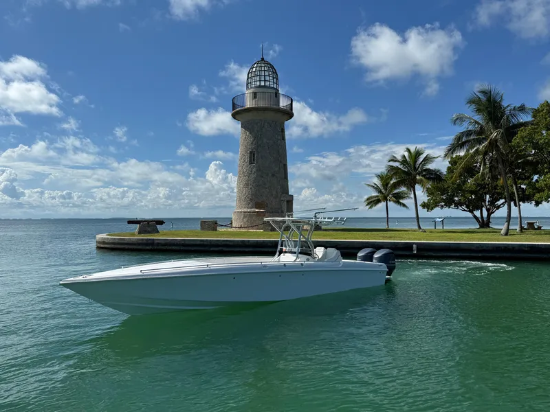Slide: The Image of 2021 Avance 33 Cabriolet boat near lighthouse, palm trees, and clear blue sky. - 3