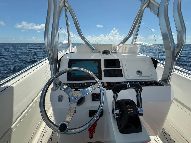 Slide: The Image of 2021 Avance 33 Cabriolet boat dashboard with steering wheel and controls, ocean view. - 8