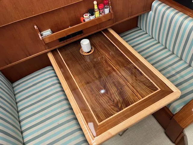 Slide: The Image of 1983 Viking Convertible yacht interior with polished wood table and striped seating. - 14