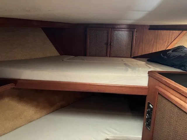 Slide: The Image of 1983 Viking Convertible cabin interior with wooden finish and cozy sleeping area. - 17