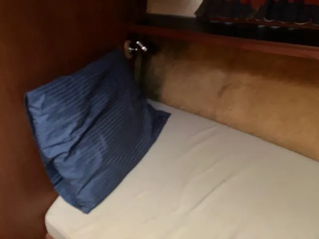 Slide: The Image of 1983 Viking Convertible cabin interior with a bed and blue pillow. - 18