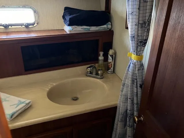 Slide: The Image of 1983 Viking Convertible boat bathroom with sink, curtain, and toiletries. - 19