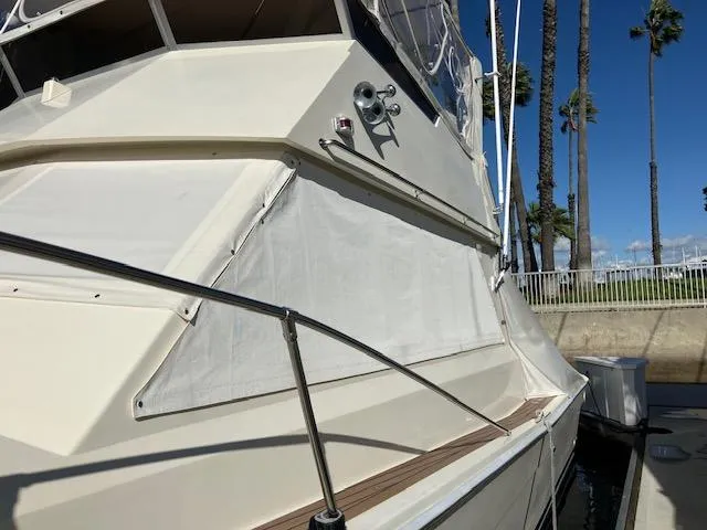 Slide: The Image of 1983 Viking Convertible yacht docked, featuring sleek design and palm trees in the background. - 2